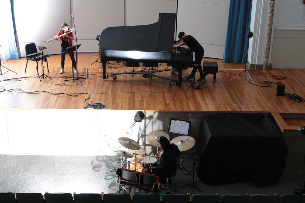 Physical distancing during the recording sessions for the debut album of Susie Ibarra's trio Talking Gong. Claire Chase (left) and Alex Peh on stage; Susie Ibarra with her drum set in the audience. (Photo by Tony Cenicola)