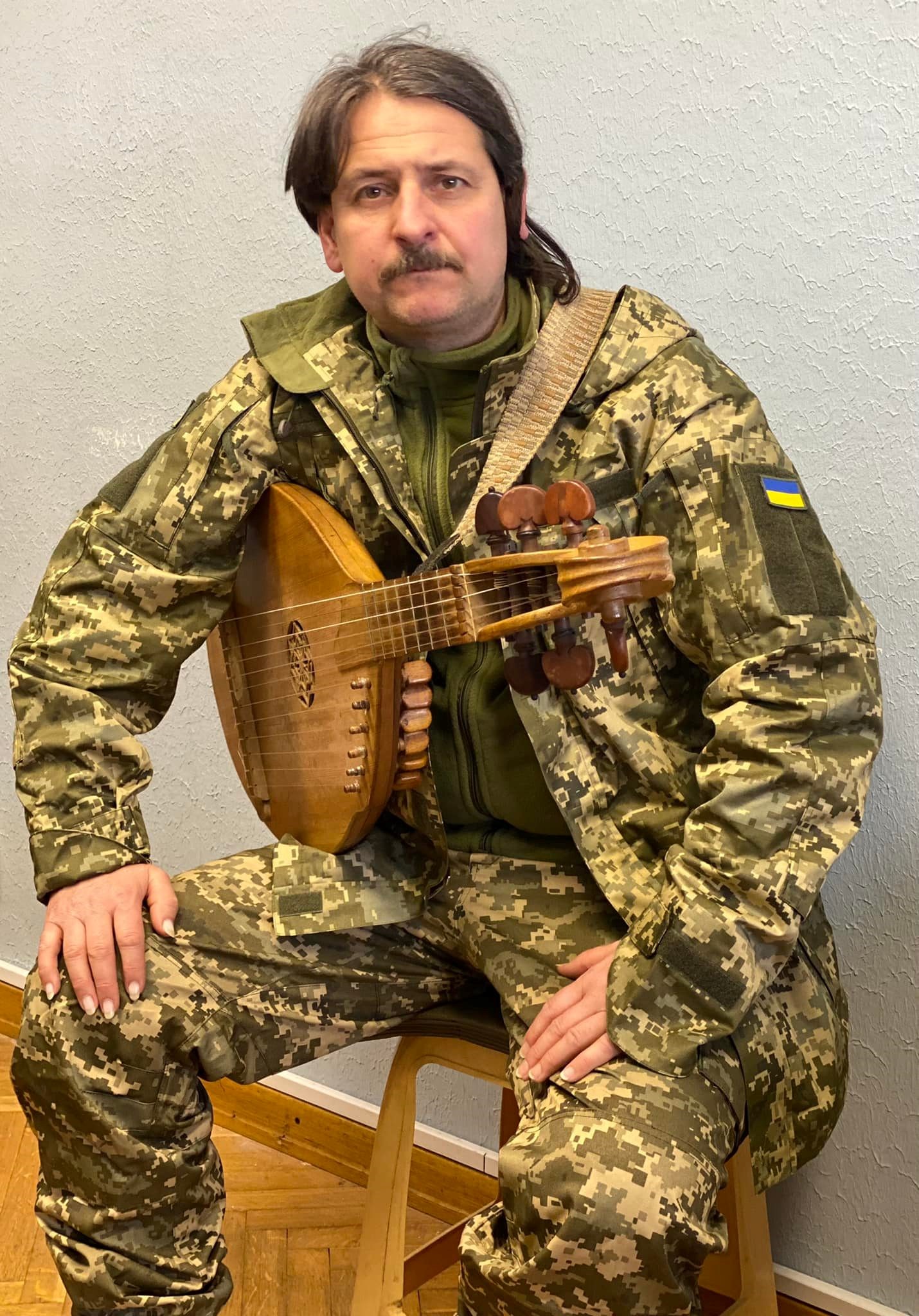 Taras Kompanichenko in a Ukrainian military uniform with a bandura.