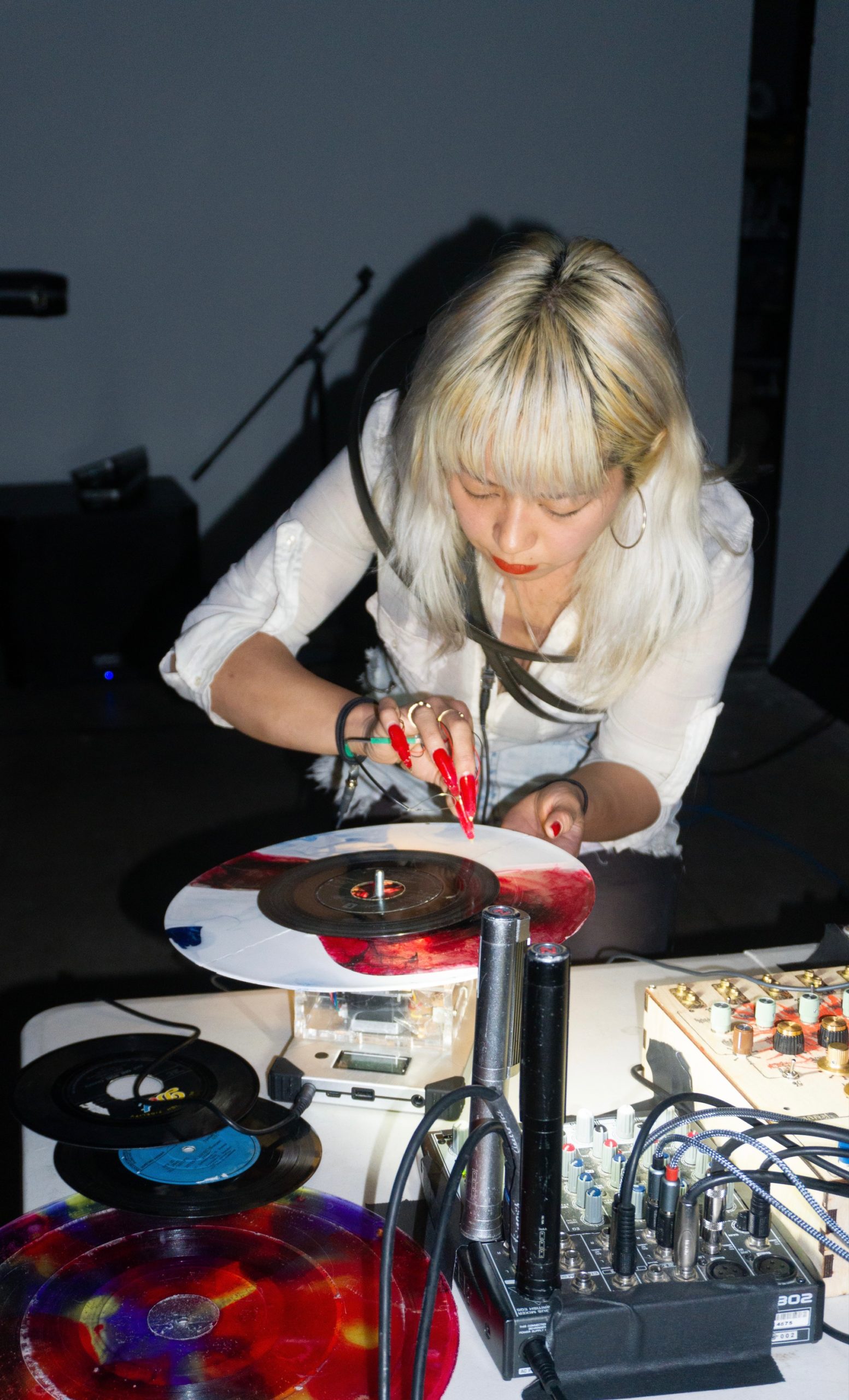 Victoria Shen scratching a record with her needle nails on a handmade turntable.