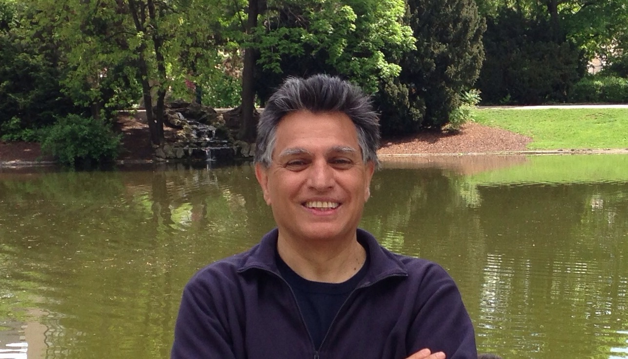 Reza Vali standing in front of a lake.